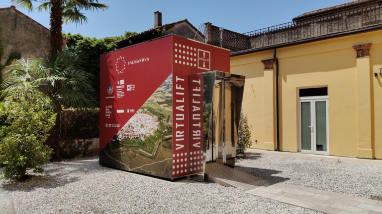 Ingresso del Virtualift di Palmanova, con una cabina rossa davanti all’edificio.