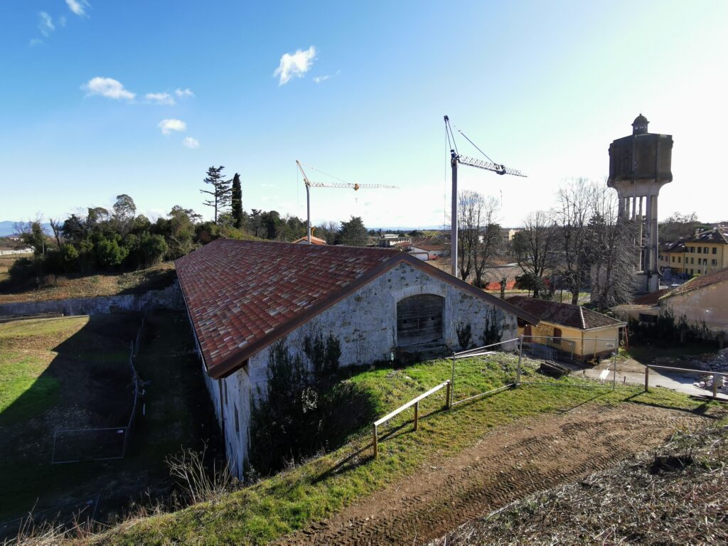 Edificio in mattoni della Caserma Filzi, accanto al fossato e ai bastioni erbosi.