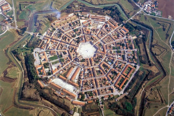Veduta aerea di Palmanova: la città a stella a nove punte con la grande piazza esagonale al centro, circondata da bastioni e fossati.